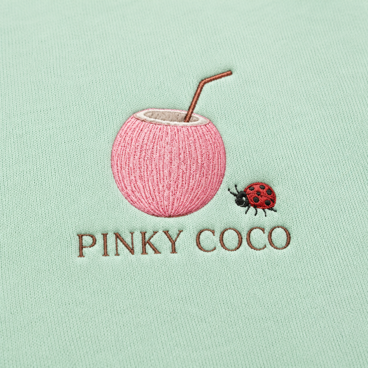 Model showing the back of the PinkyCoco Mint Ladybug Palm Garden hoodie